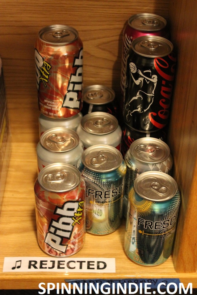 cans of soda on shelf marked "rejected" at KXSU