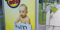 A radio station contest advertisement at a bus stop.