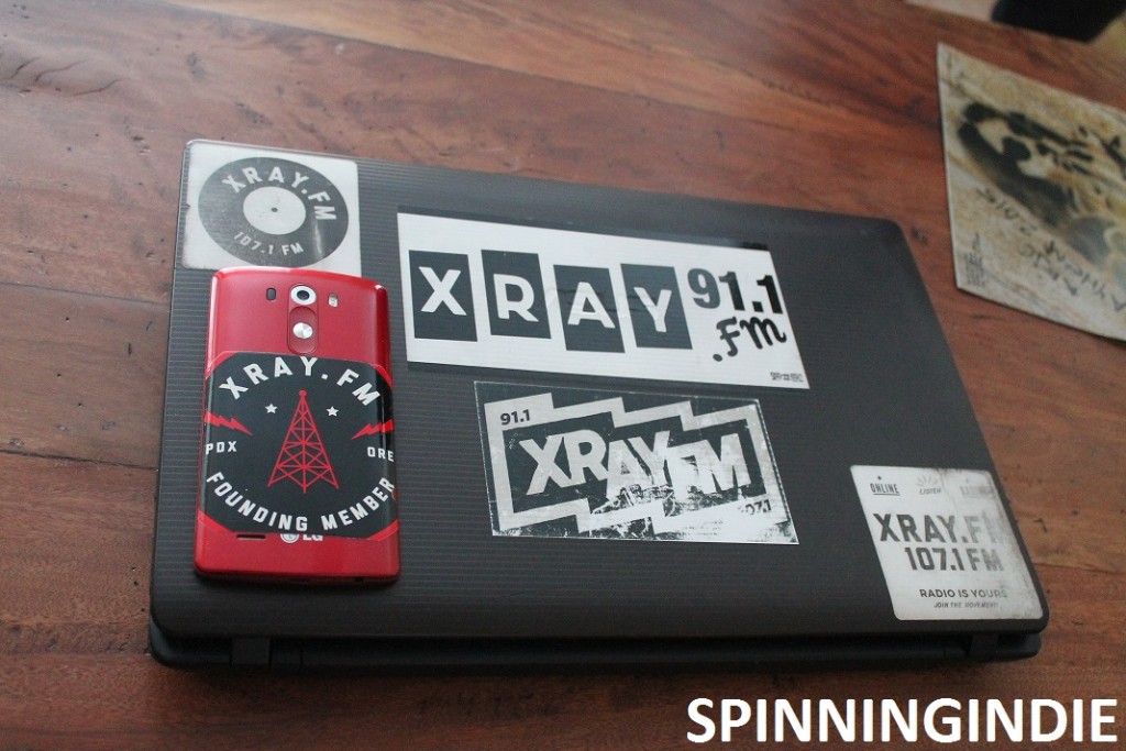 Collection of XRAY.fm stickers on laptop at community radio station. Photo: J. Waits