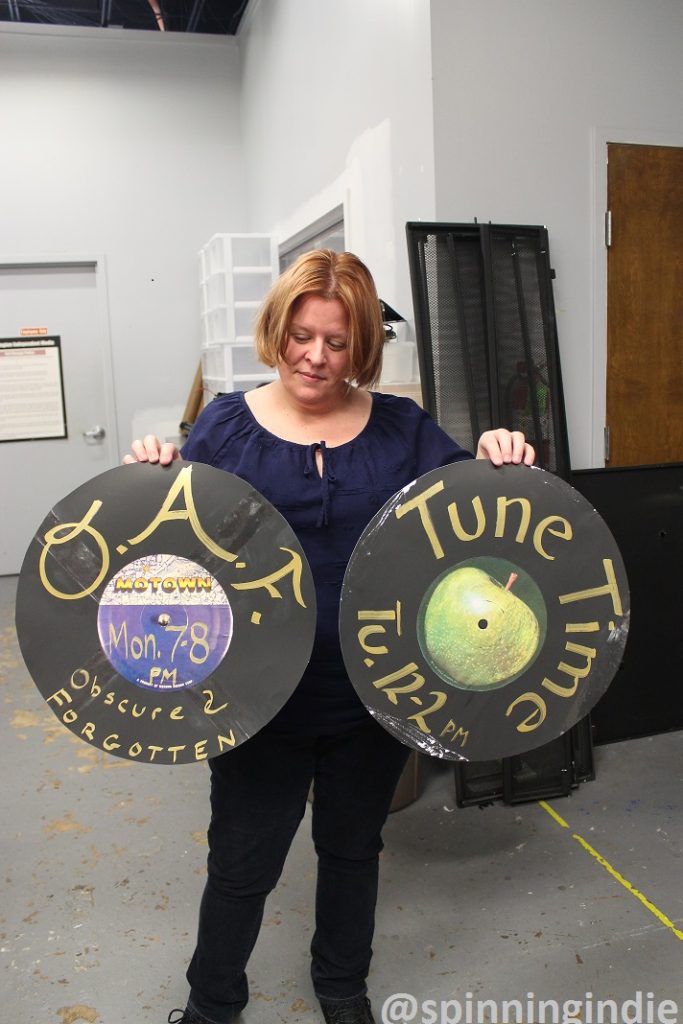 Lauree McArdle showing promotional "records" for a few WERA-LP shows. Photo: J. Waits