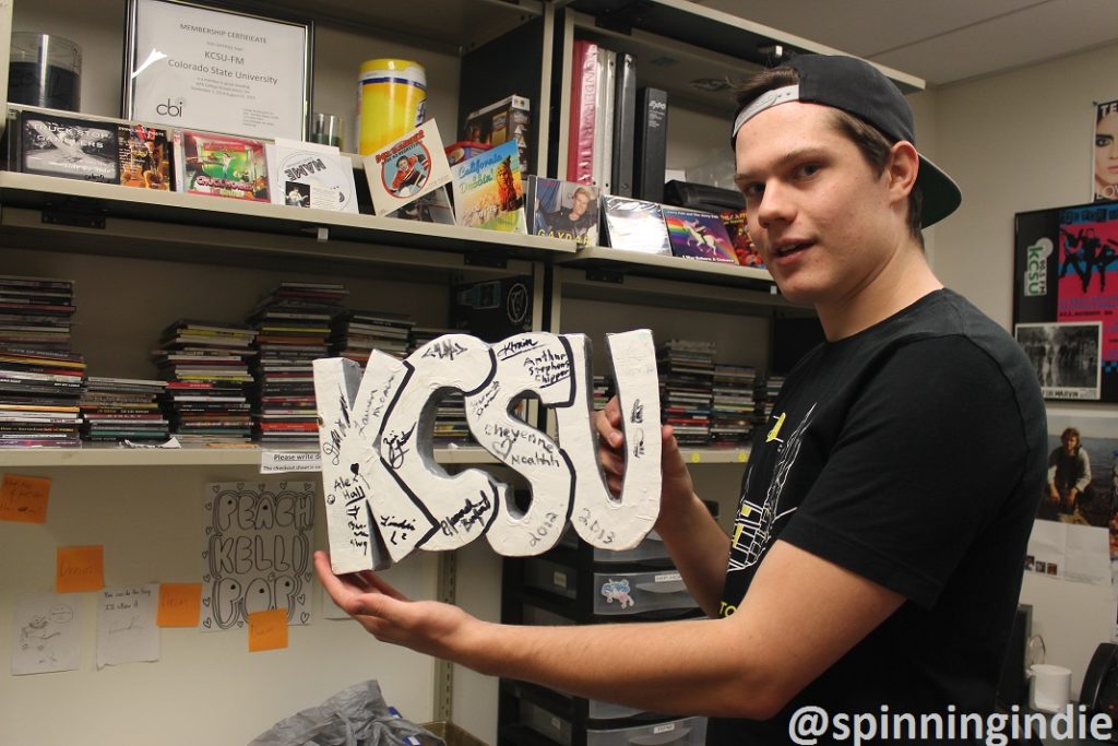 Sam Bulkley holding the Leo Blais-crafted KCSU sign. Photo: J. Waits
