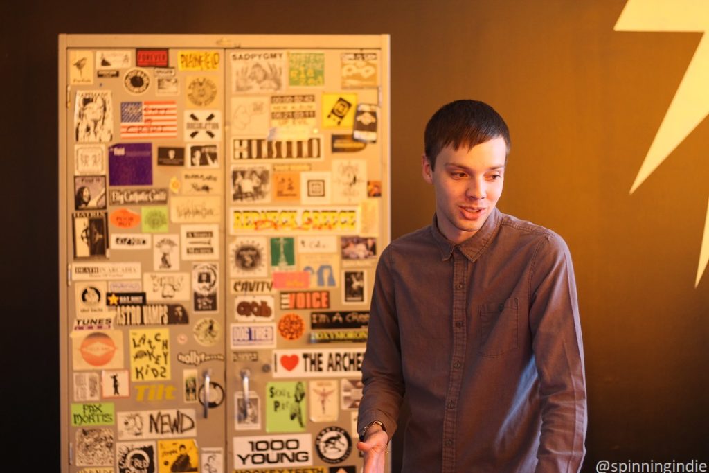 Soren Spicknall in front of sticker-covered cabinet at WIIT. Photo: J. Waits