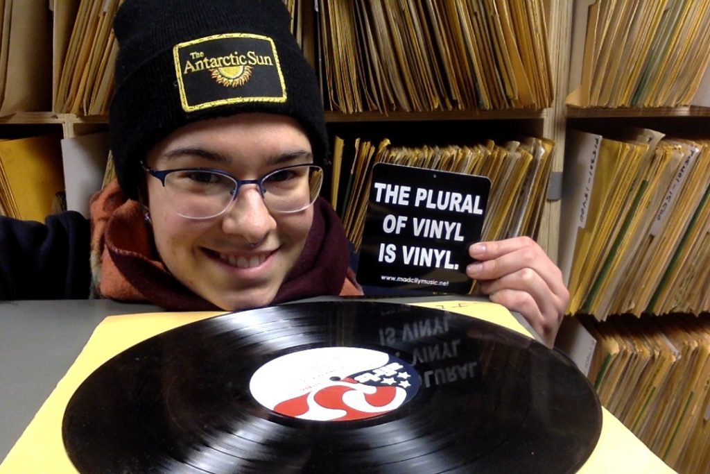 Elizabeth Delaquess in Ice Radio's vinyl library holding sticker "The plural of vinyl is vinyl." Photo courtesy Elizabeth Delaquess.