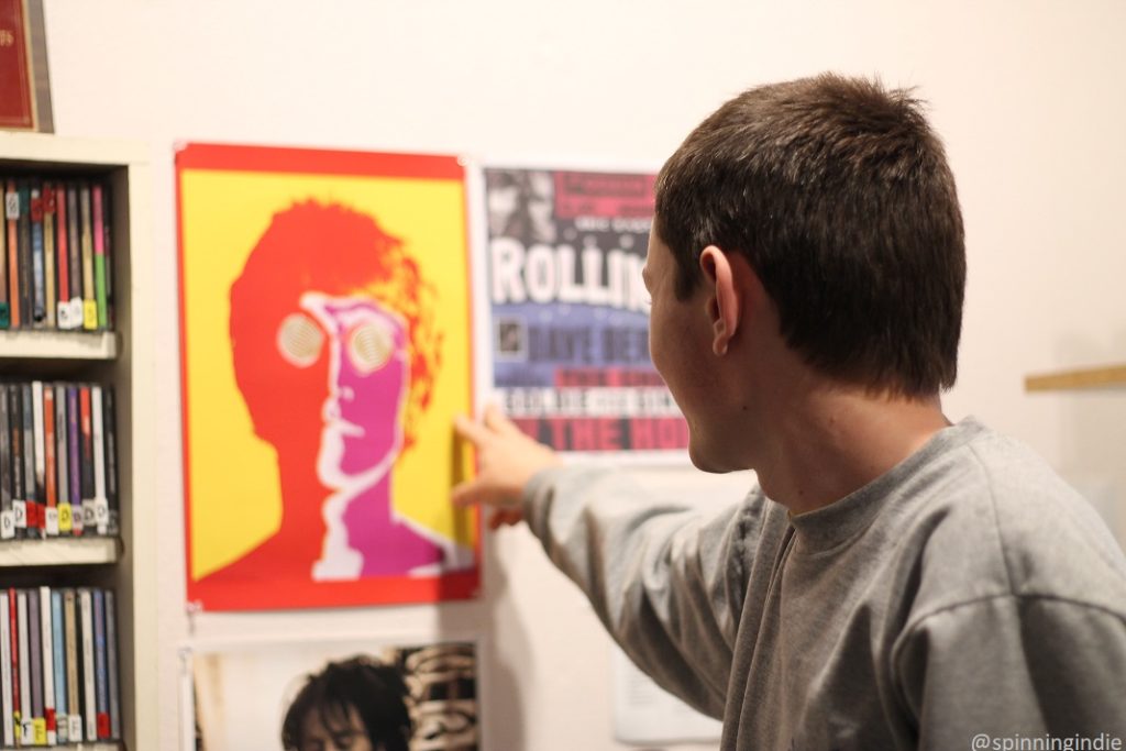 Henry Thomas points at music posters on wall of KAKX studio. Photo: J. Waits