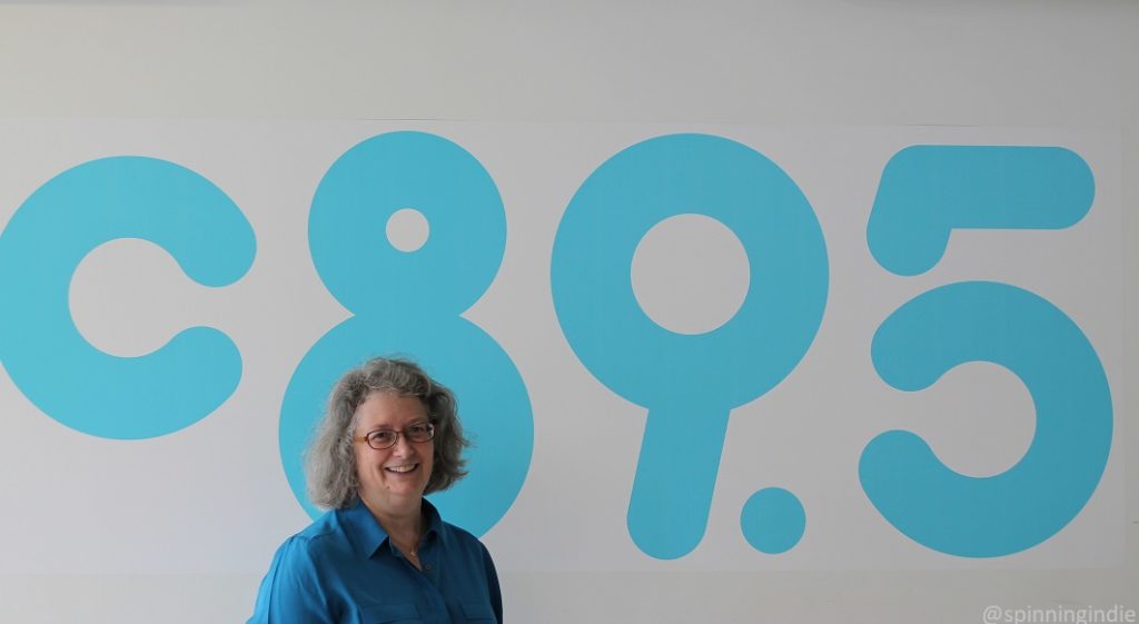 June Fox in front of C89.5 mural at the high school radio station. Photo: J. Waits