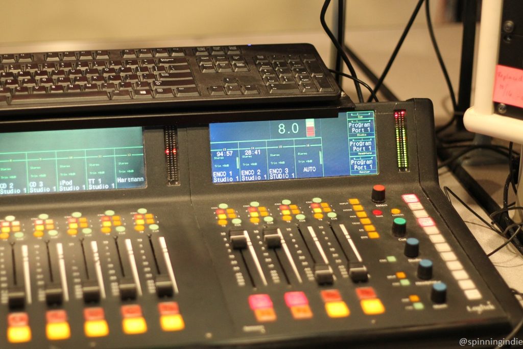 Soundboard in KBCS studio, with sliders, illuminated buttons, and a display for different inputs (ENCO, iPod, TT, CD, etc.). Photo: J. Waits/Radio Survivor