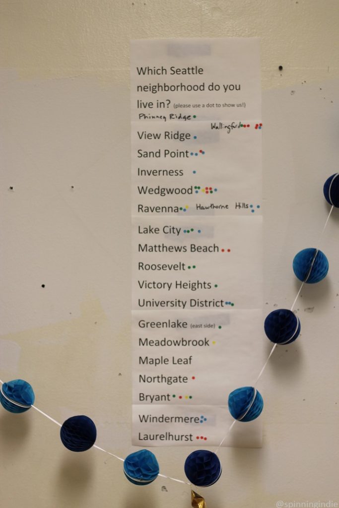 Sign on wall of KMGP: "Which Seattle neighborhood do you live in? Please use a dot to show us!" A list of neighborhoods follows, with dots next to them. Photo: J. Waits/Radio Survivor