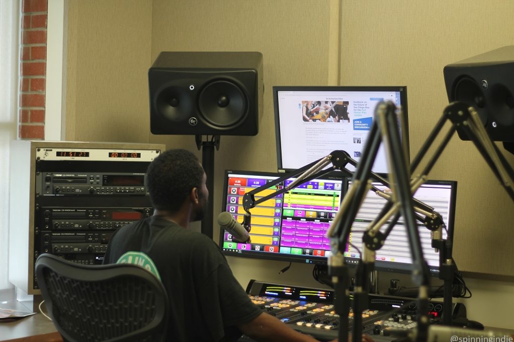 Joe Martin in SDS Radio studio. In photo: audio equipment, speakers, microphones, computer monitors, and sound board. Photo: J. Waits/Radio Survivor