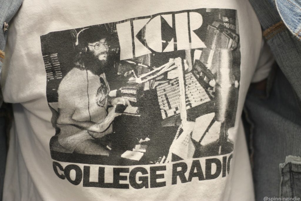 Retro KCR College Radio photo on T-shirt. Photo on T-shirt shows man in radio studio, wearing headphones in front of sound board. Photo: J. Waits/Radio Survivor