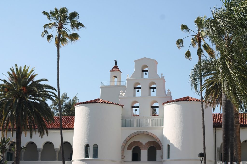 Palm trees and mission-style building with red-tiled roof and bells at San Diego State University. Photo: J. Waits/Radio Survivor