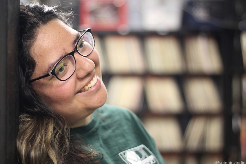 Adriana Barrios at KSDT. LPs in record library in the background. Photo: J. Waits/Radio Survivor