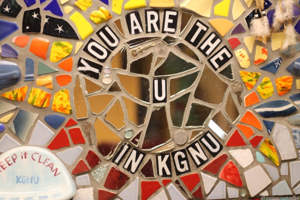 Mosaic that reads "YOU ARE THE U in KGNU" with mirror in center. Photo: J. Waits/Radio Survivor