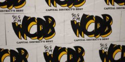 Wall of WCDB stickers. Lettering in black accented with yellow. Photo: J. Waits