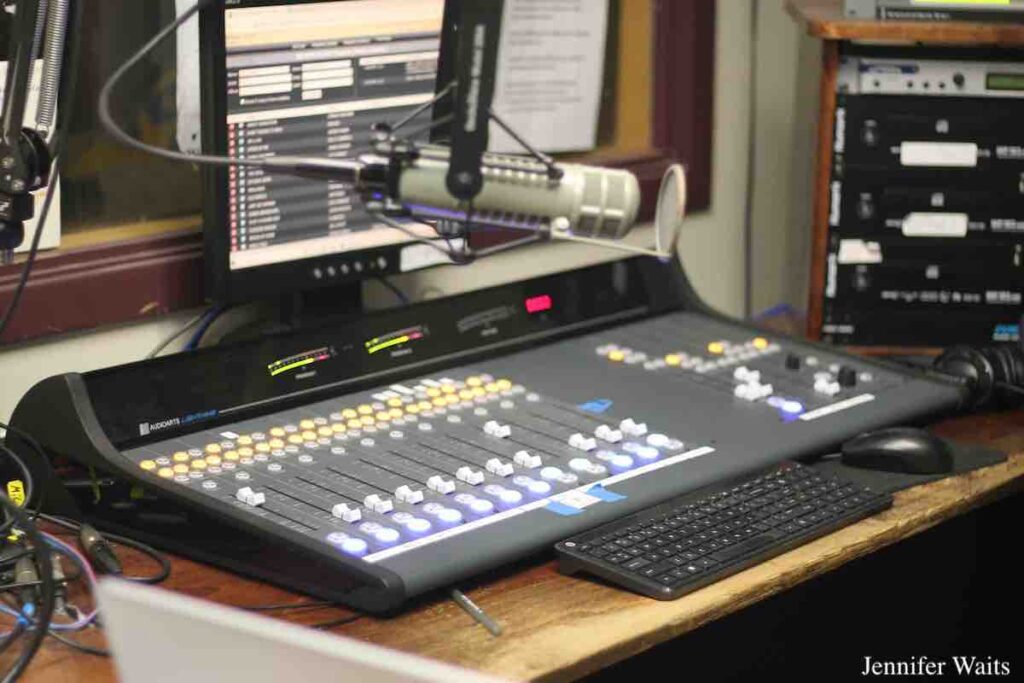 College radio station WCDB studio. Image of mixing board, microphone, computer monitor, keyboard, mouse, rack of audio equipment. Photo: J. Waits