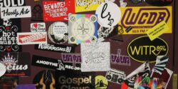 Photo of college radio station door at WCDB plastered with stickers, including WCDB sticker. Photo: J. Waits