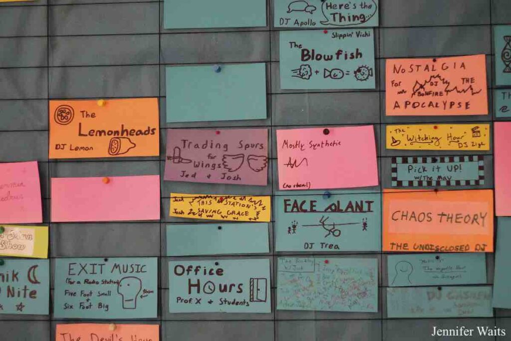 Photo of WPRI program schedule on the wall. Colorful small cards are labeled with different show names and descriptions. Photo: J. Waits
