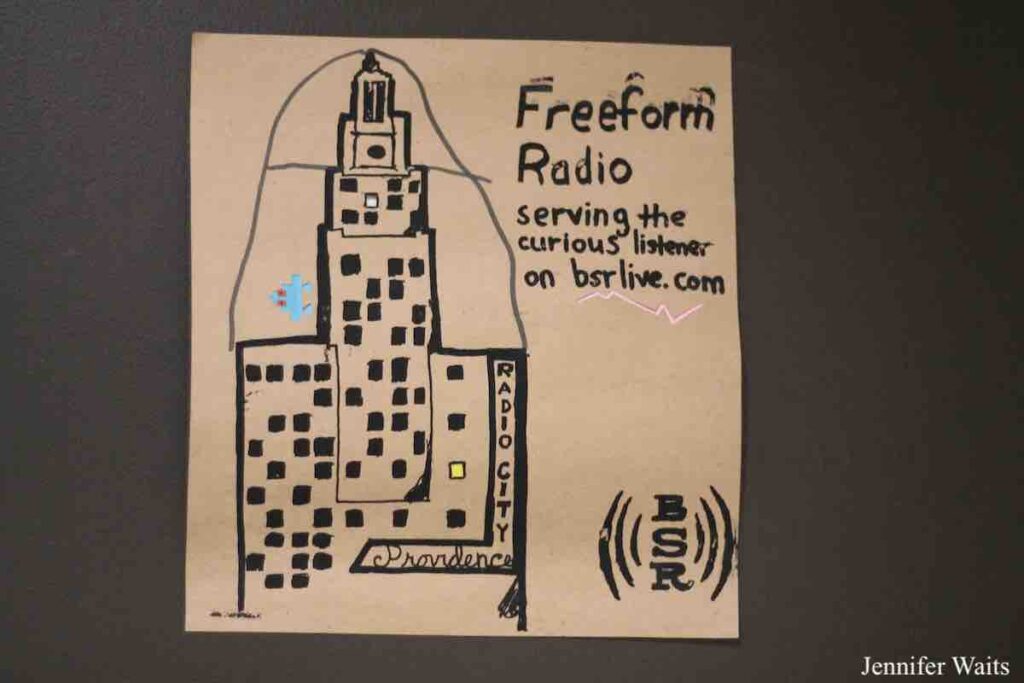 Photo of handmade flyer for college radio station BSR. Flyer has a drawing of a building. Logo BSR and text: "Freeform Radio serving the curious listener on bsrlive.com." Radio City Providence is written next to the building. Photo: J. Waits