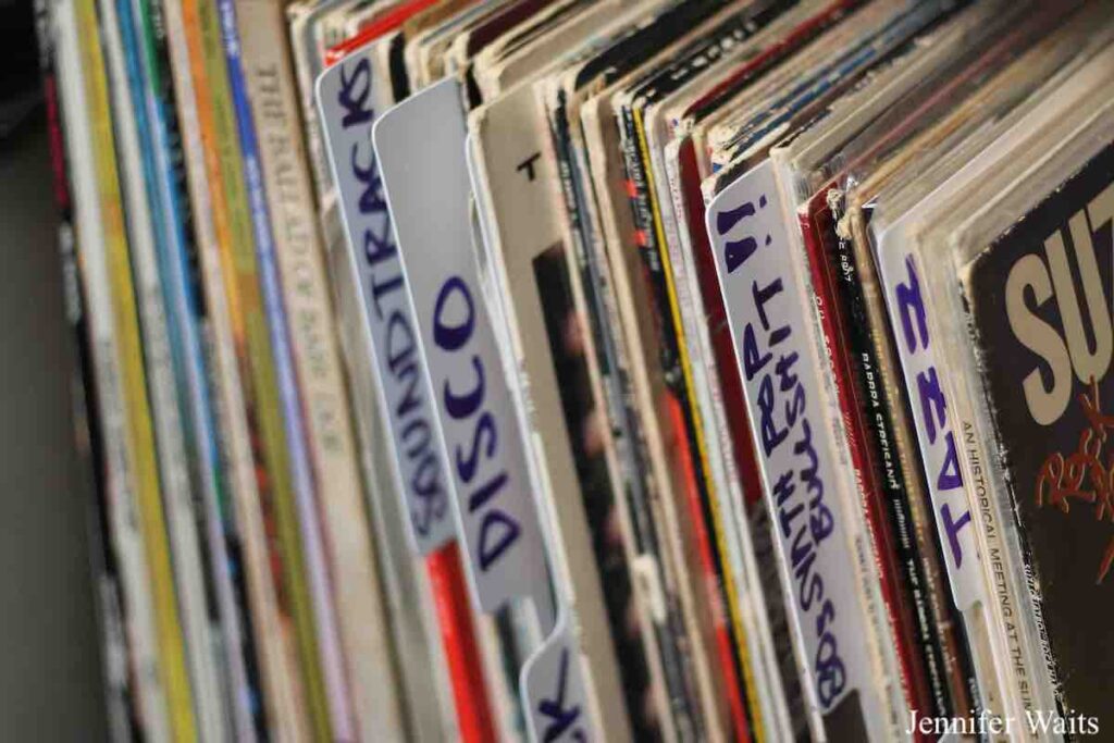 Photo of vinyl LP records at college radio station WSLC. Plastic dividers read: soundtracks, disco, 80s & synth pop bullshit!!, and jazz. Photo: J. Waits