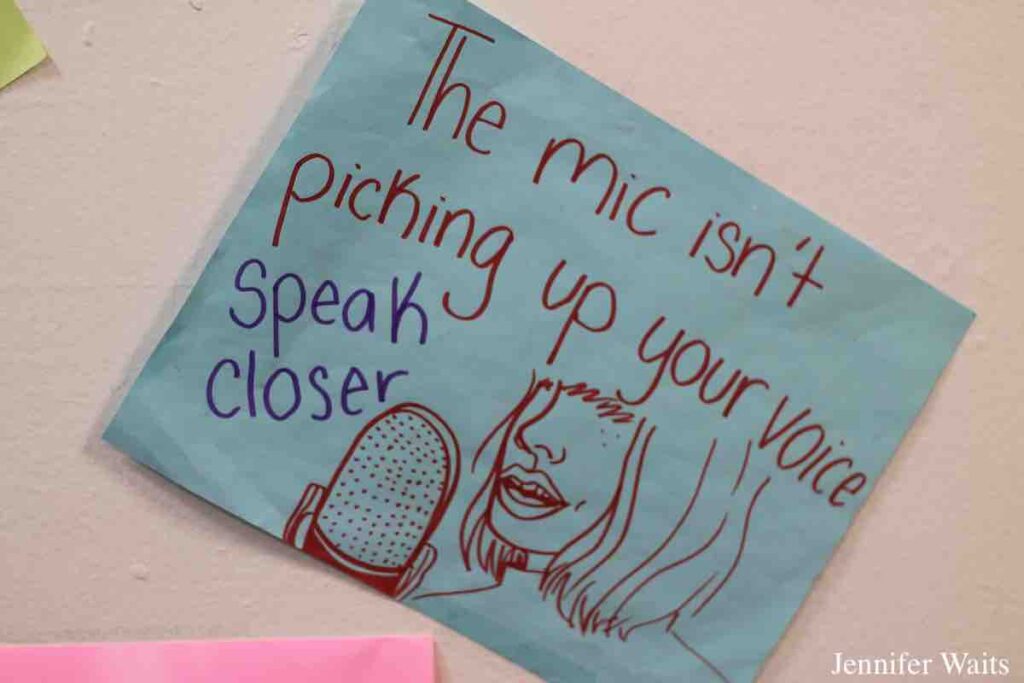 Flyer at WPIR Pratt Radio. Flyer reads: "The mic isn't picking up your voice. Speak closer" and has a drawing of a person in front of a microphone. Photo: J. Waits