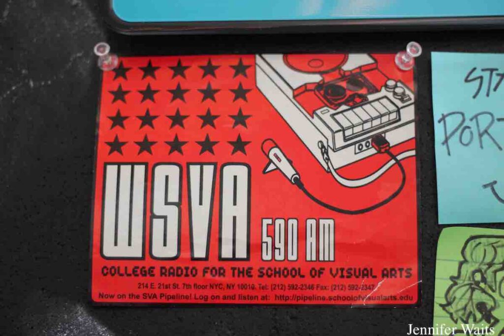 Vintage sticker on the wall of college radio station WSVA in spring 2023. Sticker has a drawing of a portable cassette player and says: "WSVA 590AM College Radio for the Schcool of Visual Arts..Now on the SVA Pipeline! Log on and listen..." Photo: J. Waits