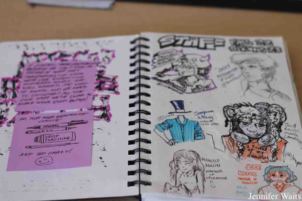 Photo of WSVA Sketchbook at the college radio station in March, 2023. One page has a few post-its with handwritten notes. Another page has drawings of WSVA staff members. Photo: J. Waits