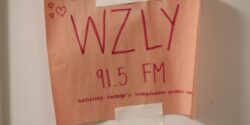 Pink paper sign with WZLY 91.5 FM written on it in red ink. Photo by J. Waits
