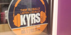 Photo of KYRS logo on the window of the community radio station. Logo reads: Think globally, listen locally KYRS" Photo by J. Waits