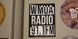 Photo of WMUA Radio 91.1 FM black and white sticker affixed to a metal cabinet at the UMass Amherst college radio station. Photo: J. Waits