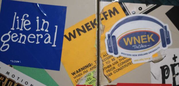 Photo of metal cabinet covered with stickers, including several for WNEK, the college radio station at Western New England College. Photo: J. Waits